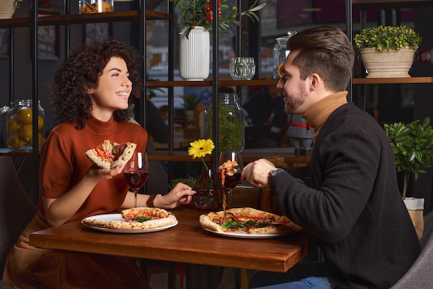 Pareja disfrutando pizza El Conta